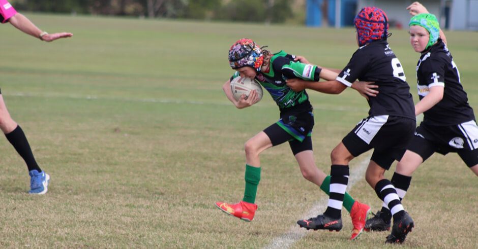 Young rugby athlete struggles to carry ball during the game at Proserpine Whitsunday Junior Rugby League